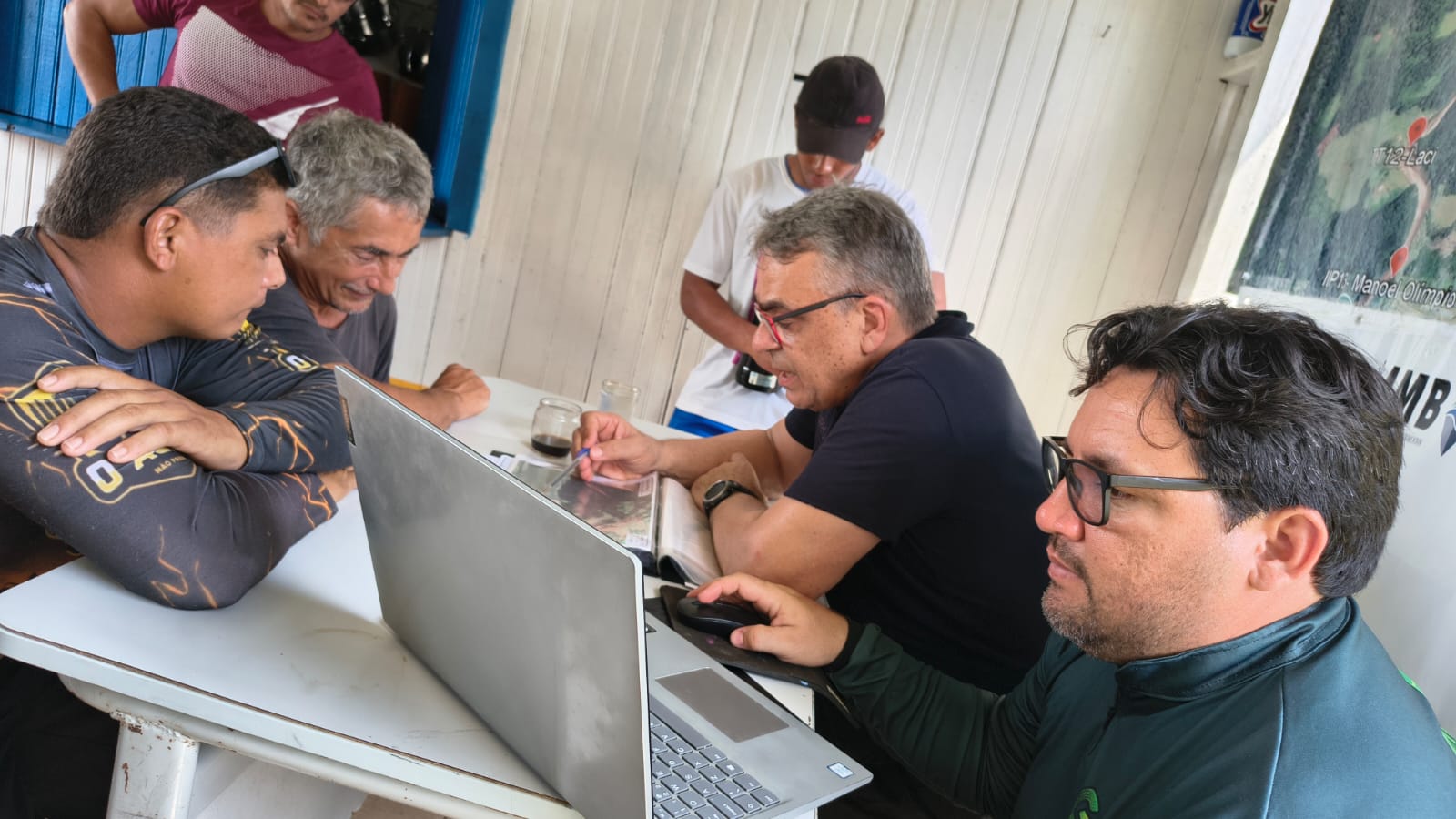 Equipe analisando imagens de satélite com moradores