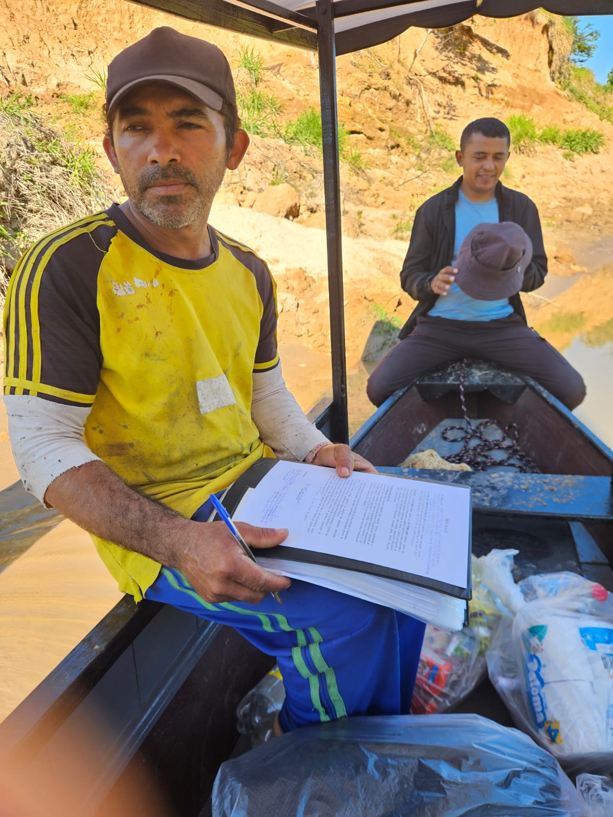 Morador assinando documentação no barco