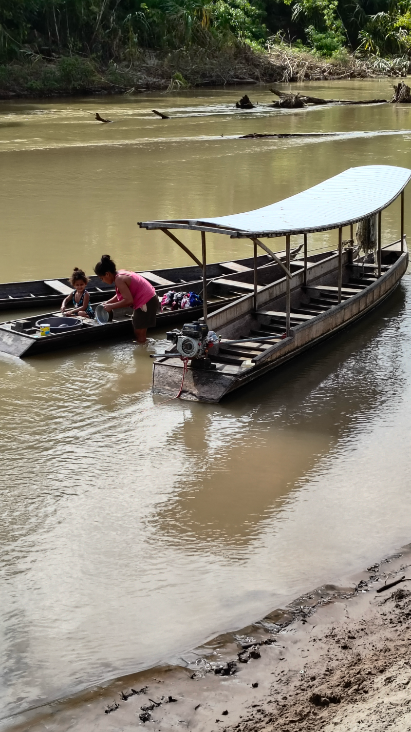 Mulheres lavando louça na beira do rio