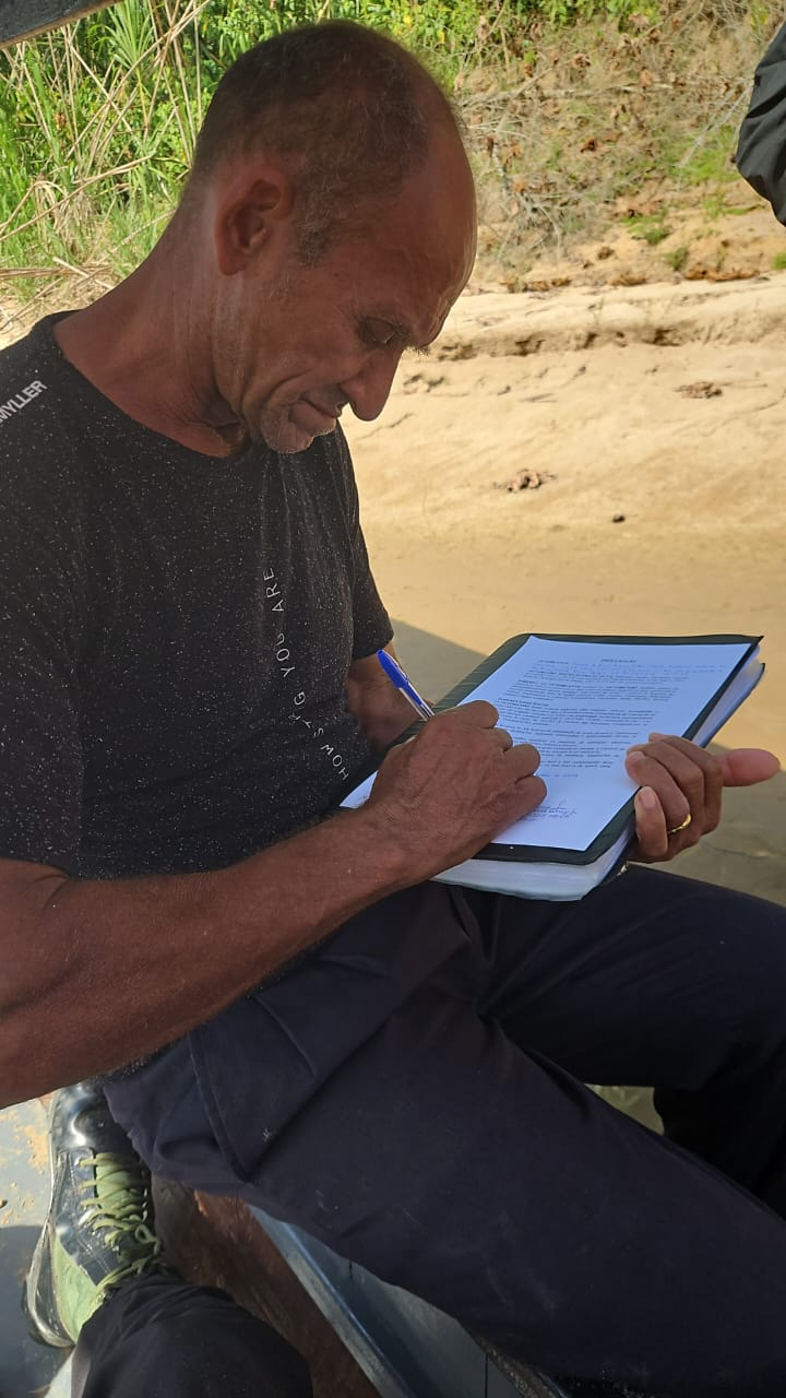 Morador assinando a documentação da propriedade